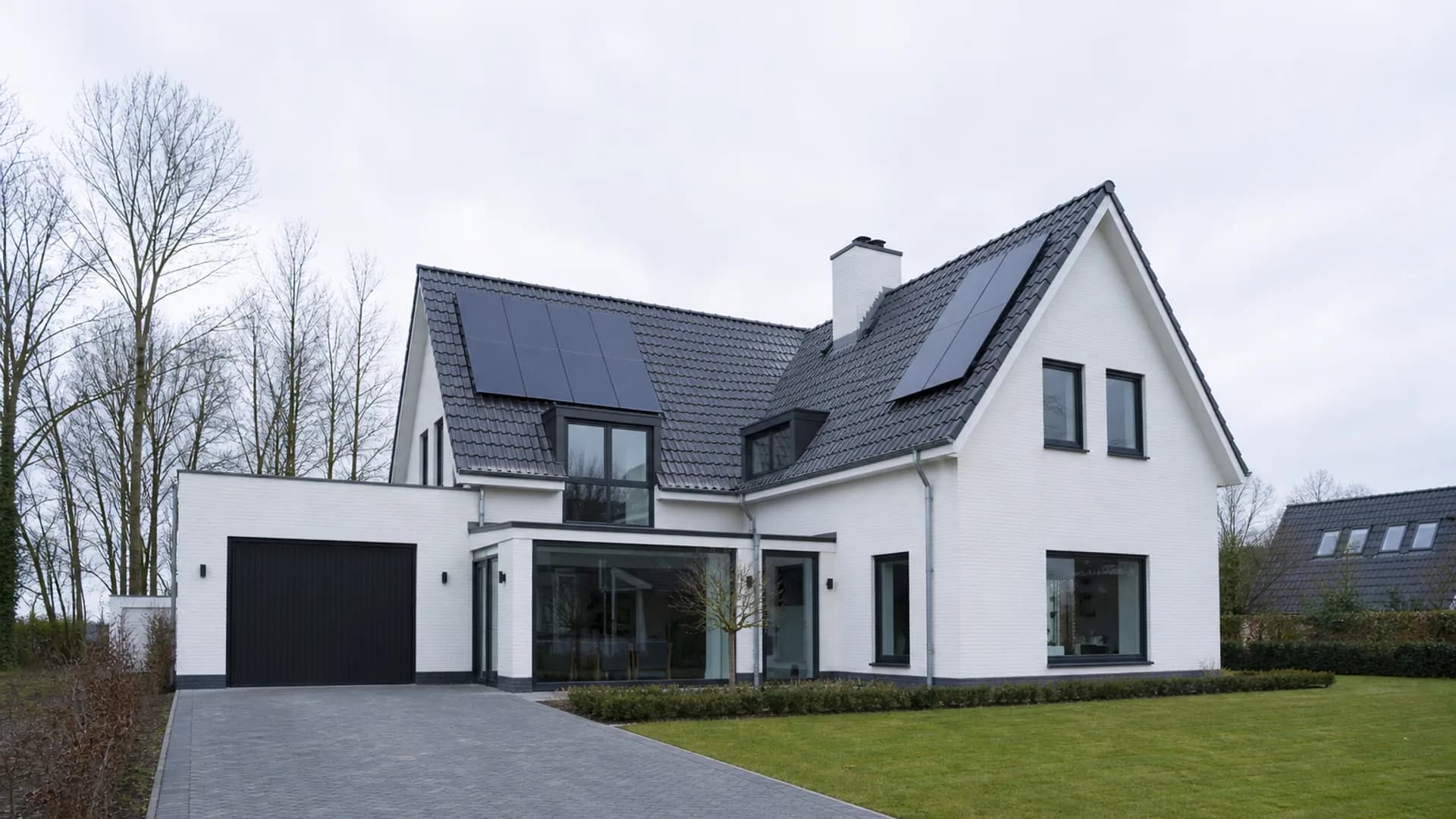 Witte Nederlandse woning met zonnepanelen op een heldere bewolkte ochtend met koel daglicht.